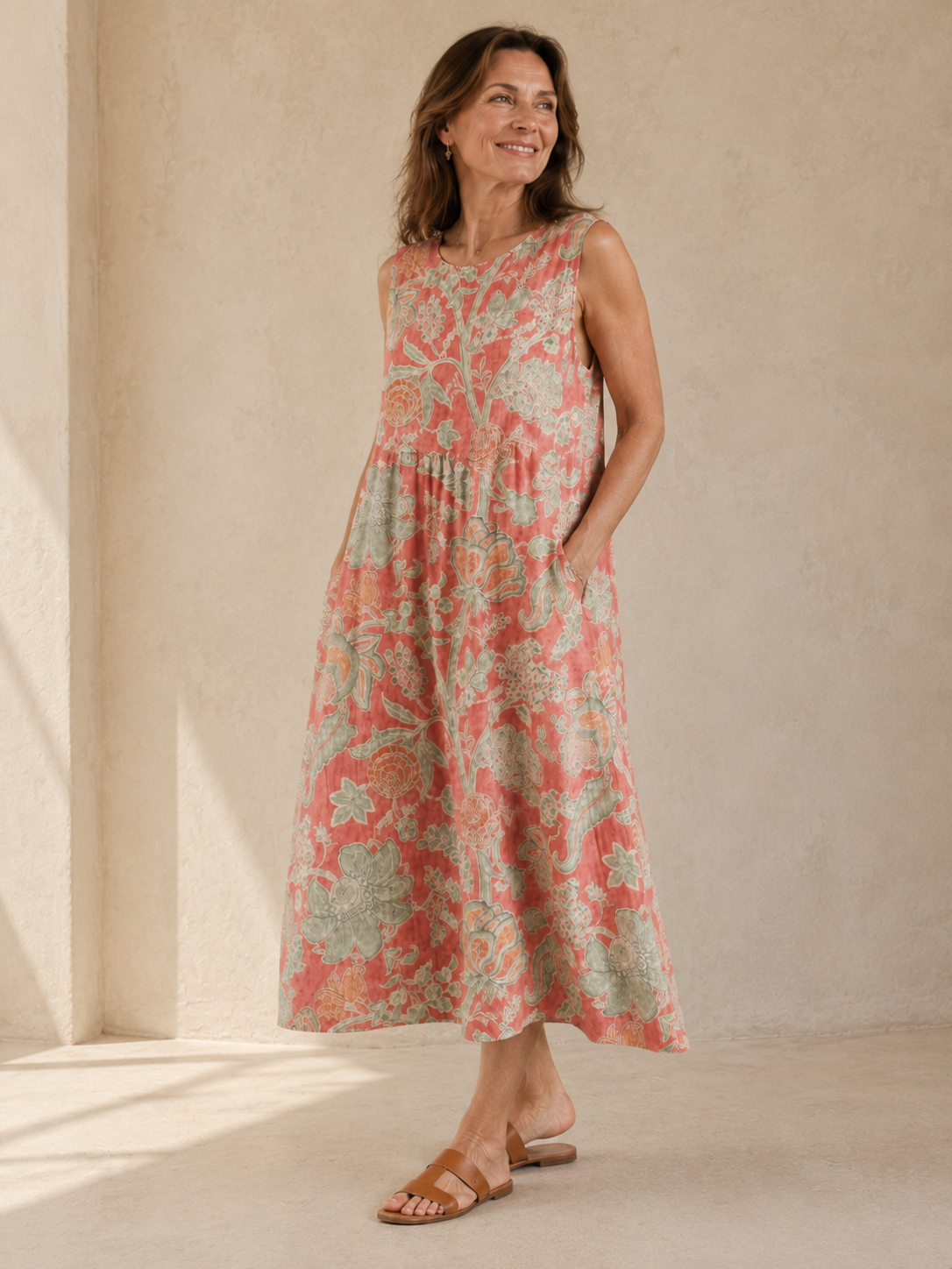 Beth - Robe Midi Florale in een luxe studiosetting met warme kalkstenen achtergrond, met koraalroze linnen, zachte saliegroene bloemenprint, ronde hals, midi lengte en vloeiende A-lijn snit.